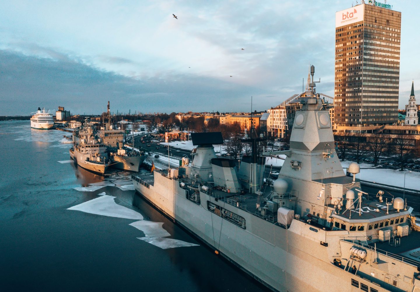 An aerial shot of big military ships in a harbor during winter